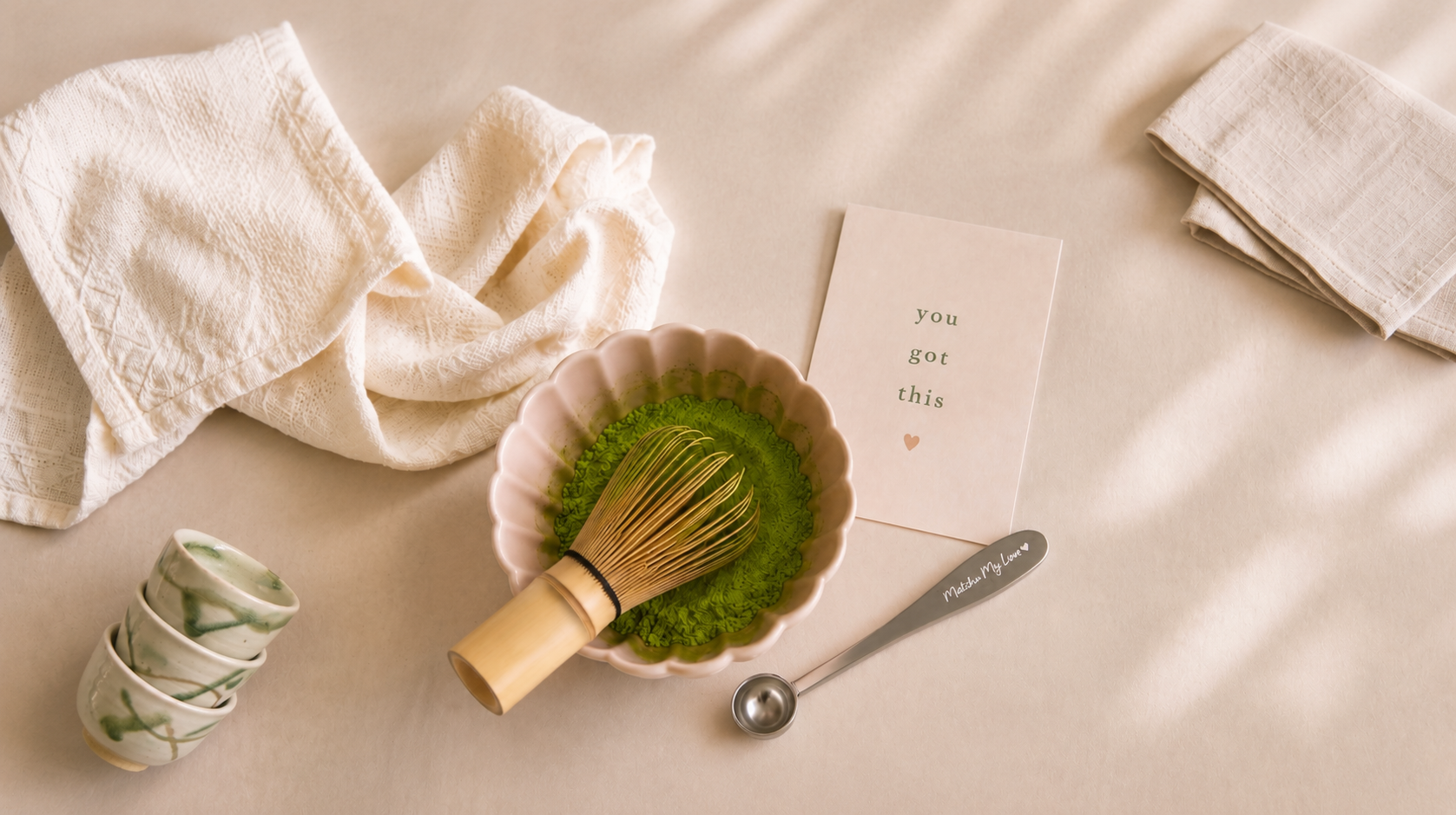 Matcha bowl with whisk, spoon, card and folded linen napkins